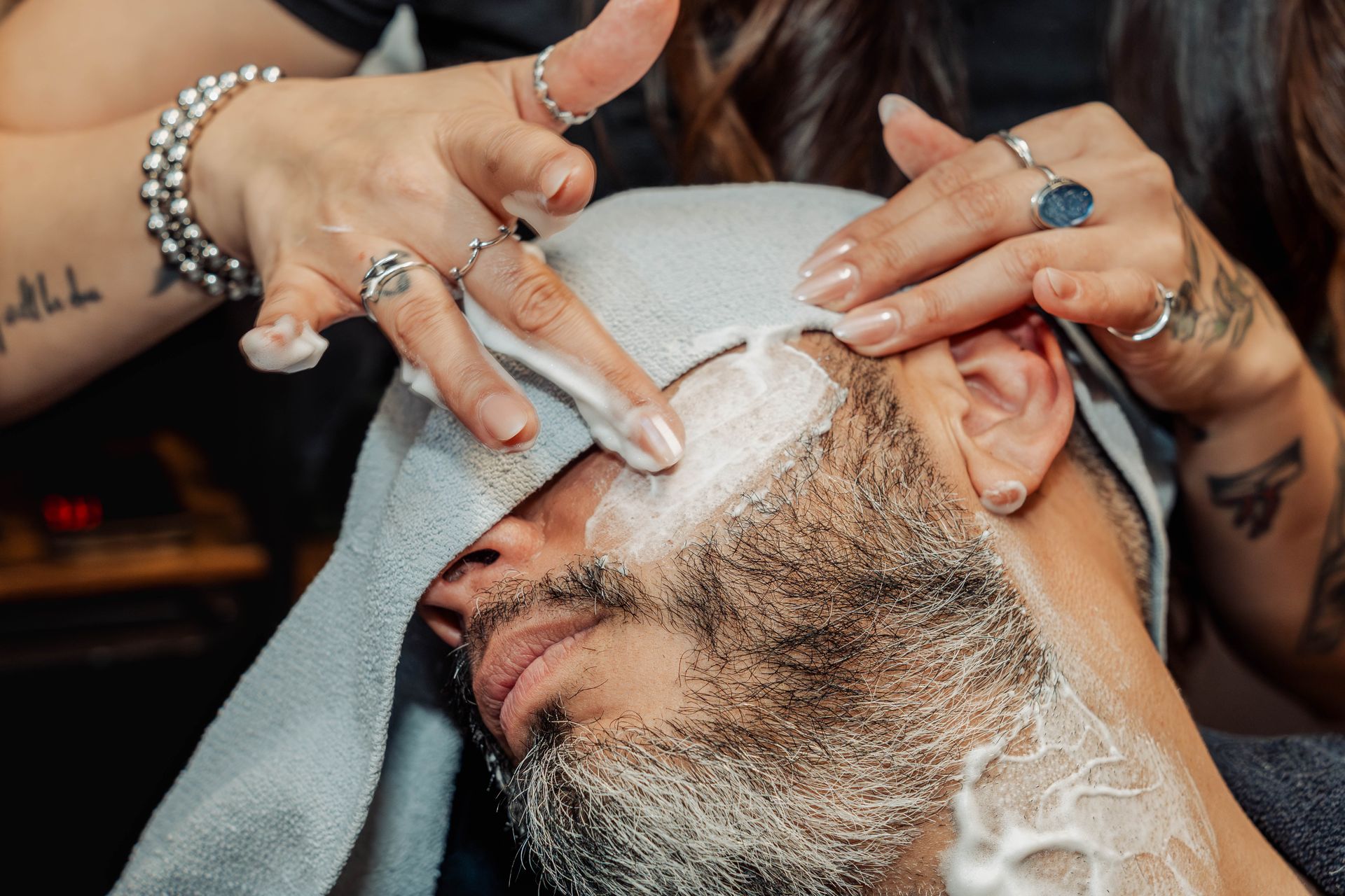 Hot towel beard treatment during a shave service at The Speakeasy Barber