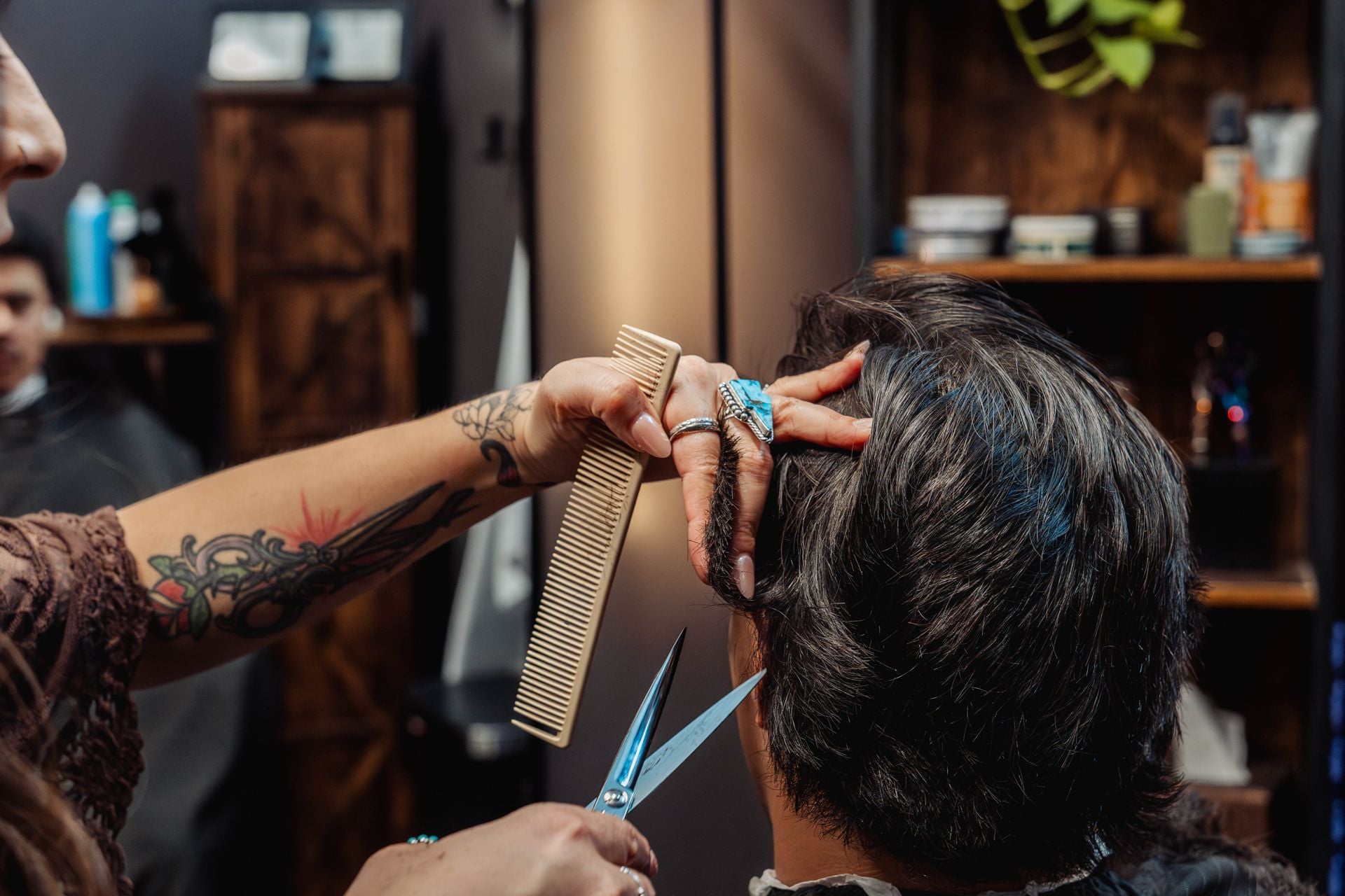 Victoria smiling with a client during a haircut at The Speakeasy Barber